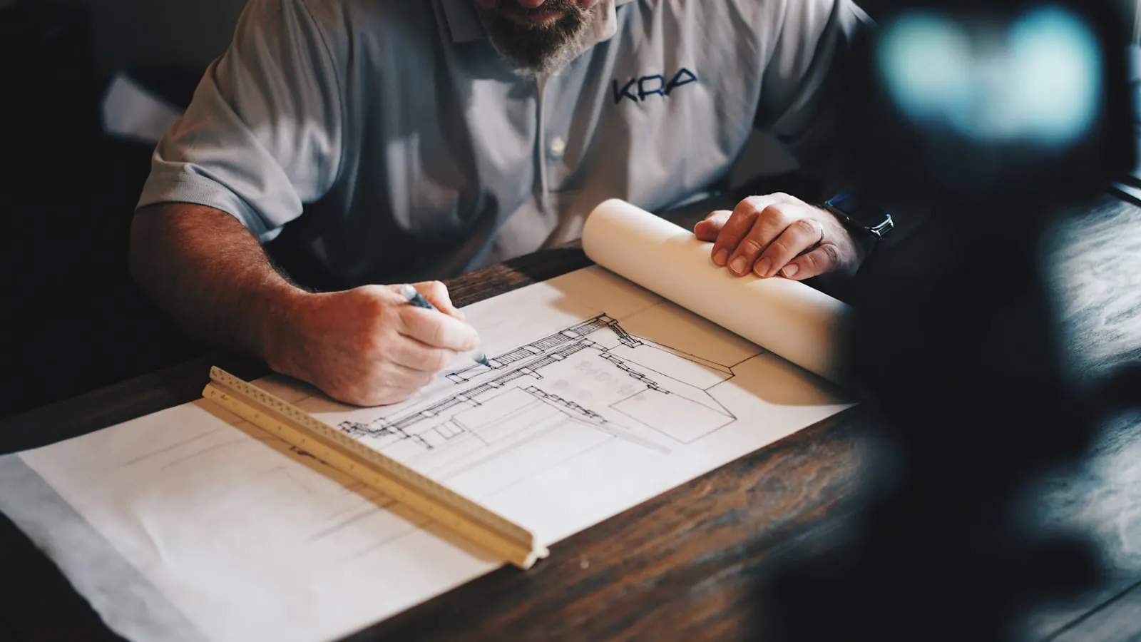 Hand drafting a building section with a scale ruler